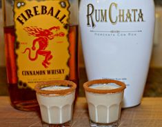 two shot glasses filled with cinnamon whiskey next to a bottle of rumchata