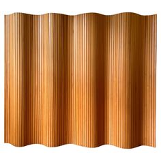 an orange curtain with vertical pleating on the top and bottom, in front of a white background