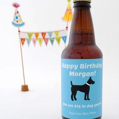 a beer bottle with a birthday card on it next to a party hat and bunting