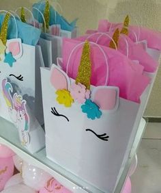 several bags with unicorns on them are sitting on a shelf in front of balloons