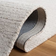 a close up of a rug on the floor with a wooden floor in the background