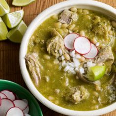 a white bowl filled with soup next to sliced radishes and celery