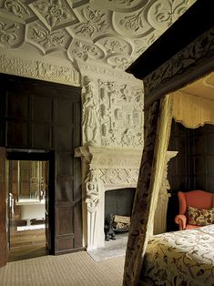 an ornately decorated bedroom with a fireplace and bed in the corner, next to a doorway