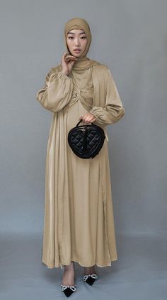 Introducing the Aigerim2 Piece Luxury Abaya from Annah Hariri, the epitome of sophistication and style. This stunning abaya set is crafted from high-quality satin fabric, ensuring both comfort and durability. The beige color exudes luxury and will leave a lasting impression wherever you go.The abaya features a maxi slip dress with maxi sleeves that provide full coverage and comfort. The wrap bodice adds a touch of elegance and femininity, while the elasticated cuffs offer a secure and snug fit. Eid Wedding Solid Color Abaya, Floor-length Beige Abaya For Eid, Elegant Beige Abaya For Eid, Elegant Long Beige Abaya, Cream Long Abaya For Eid, Cream Abaya For Eid, 2 Piece Abaya, Annah Hariri, Luxury Abaya