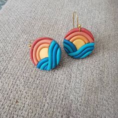 the earrings are made out of polymer and have multicolored waves on them