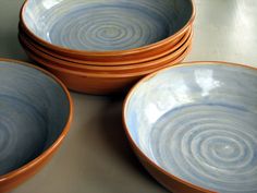 four brown and blue bowls stacked on top of each other