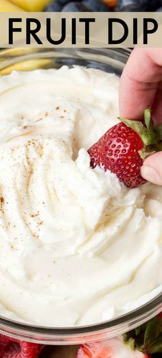 a hand dipping a strawberry into a bowl of fruit dip with the words, how to make fresh fruit dip