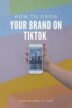 a person holding an iphone with the text how to grow your brand on tiktok