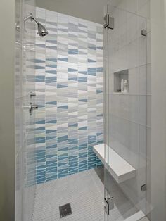 a walk in shower sitting next to a tiled wall