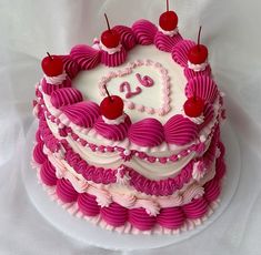 a heart shaped birthday cake with cherries on top