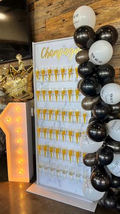 champagne party decorations with balloons and lights on the wall next to a sign that says champagne