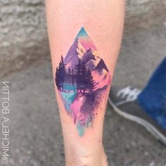 a person with a tattoo on their leg that has mountains and trees painted on it