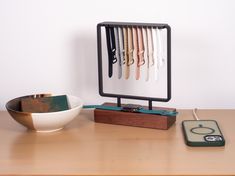 a wooden table topped with a bowl and knife holder next to a plate filled with knives