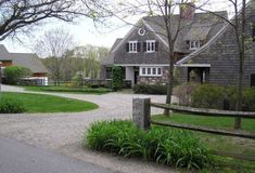 a large house sitting next to a lush green field