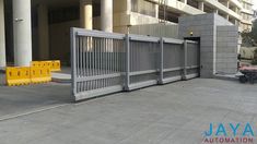 an image of a gated entrance to a building with yellow barricades around it