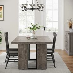 a dining room table with chairs and a potted plant on top of the table