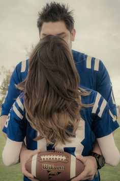 a man and woman holding a football in their hands