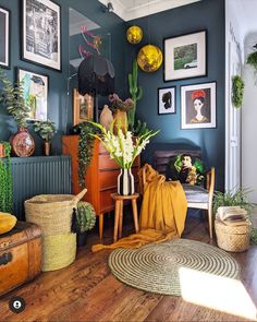 a living room filled with lots of plants and pictures