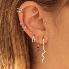 a close up of a woman's ear with earrings on her left and right side