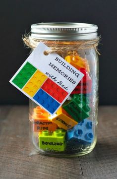 a mason jar filled with legos sitting on top of a wooden table