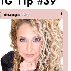 a woman with curly hair is looking at the camera and has her hand on her chin