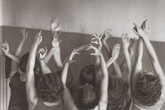 several girls reaching up to reach something in the air