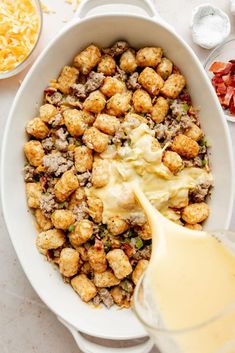 a white bowl filled with tater tots next to bowls of cheese and other ingredients