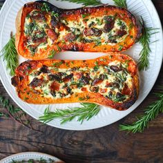 two slices of stuffed sweet potatoes on a white plate with green sprigs next to them