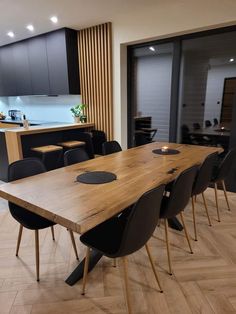 a large wooden table surrounded by black chairs