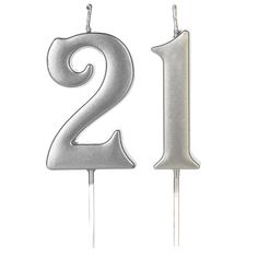 two candles with the number one on them in silver and white frosting, set next to each other