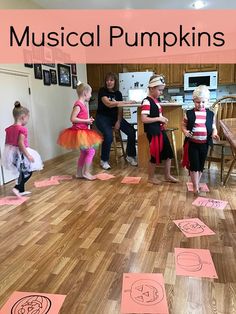 several children are standing in a room with musical pumpkins on the floor and cut out letters