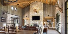 a rustic dining room with stone fireplace and wooden ceiling