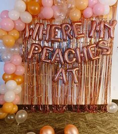 there are balloons and streamers in front of a sign that says, whatever peaches at