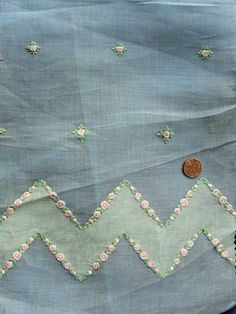 a piece of cloth with flowers on it next to a coin and some fabric material