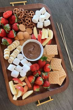 a platter filled with cheese, crackers and strawberries