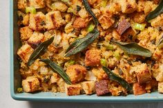 a blue dish filled with stuffing and vegetables