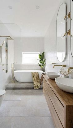 a white bathroom with two sinks and a bathtub