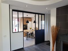 an open door leading to a kitchen and dining room with black accents on the walls