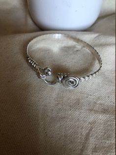 This is a handcrafted bangle/bracelets. It is designed with an oval shape to ensure a proper fit. It is the perfect gift for mothers, sisters, birthdays, daughters, and lovers. This is a simple classy bracelets.  It is  5mm in wide, , handcrafted wire-wrapped bangle bracelet, wire wrapped in sterling silver. A dainty, elegant bracelet that can be used as statement jewelry. As a Caribbean person St.Croix born and raised) these hook-styled bracelets are known to bring good luck or a meaningful ges Elegant Spiral Hand Wrapped Jewelry, Sterling Silver Hand Wrapped Bangle, Hand Wrapped Sterling Silver Bangle, Adjustable Sterling Silver Bangle, Artisan Sterling Silver Bangle Bracelet, Hand Wrapped Sterling Silver Bracelet, Artisan Silver Bangle Hand Wrapped, Elegant Hand Wrapped Adjustable Sterling Silver Bracelet, Elegant Adjustable Hand Wrapped Sterling Silver Bracelet