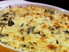 a casserole dish with cheese and spinach in it on a table top