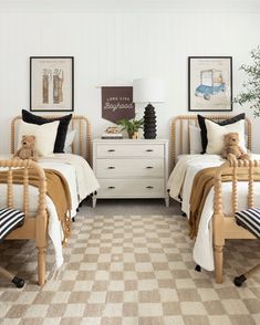 two twin beds with teddy bears on them in a white and black bedroom decorated with checkered rugs