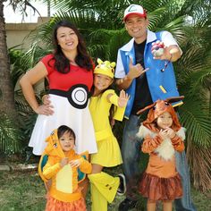 a family dressed up in pokemon costumes posing for a photo with their child's hand out