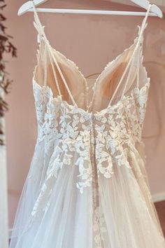 a wedding dress hanging on a hanger