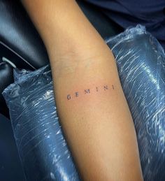 a woman's arm with the word gemini written in cursive font