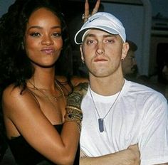 a man standing next to a woman in a white shirt and black dress with tattoos on her arm