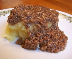 a close up of a plate of food with potatoes and meat toppings on it