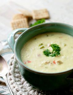 chicken velvet soup in a green bowl with crackers on the side