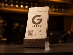 a close up of a business card on a table in front of a bar with wine glasses