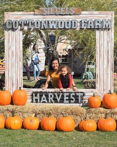 two women and a child are posing in front of a sign for the cottonwood farm