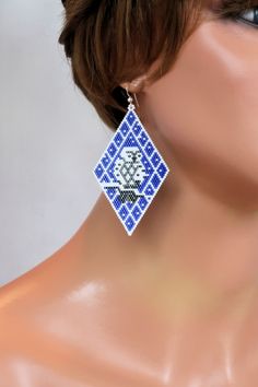 a close up of a mannequin's head wearing blue and white earrings